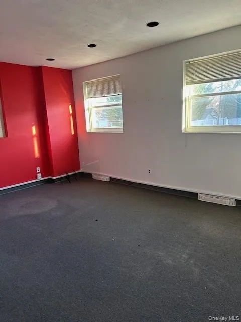 Unfurnished room featuring dark carpet and a textured ceiling Unfurnished room featuring dark carpet and a textured ceiling