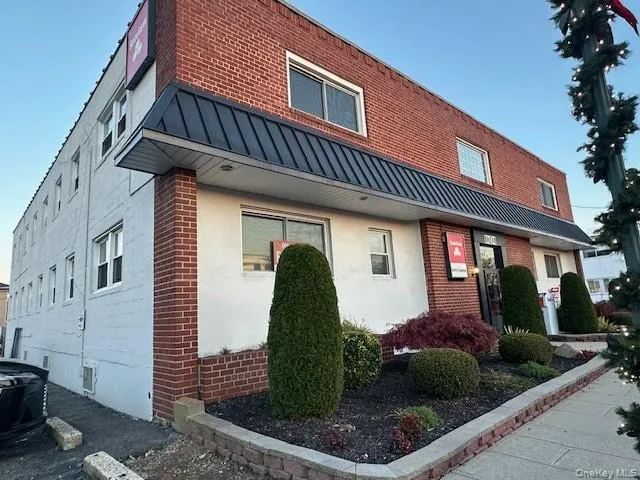 View of property exterior featuring a standing seam roof, a metal roof, brick siding, and stucco siding View of property exterior featuring a standing seam roof, a metal roof, brick siding, and stucco siding