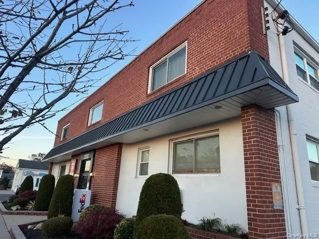 View of side of property with a standing seam roof, brick siding, a metal roof, and stucco siding View of side of property with a standing seam roof, brick siding, a metal roof, and stucco siding