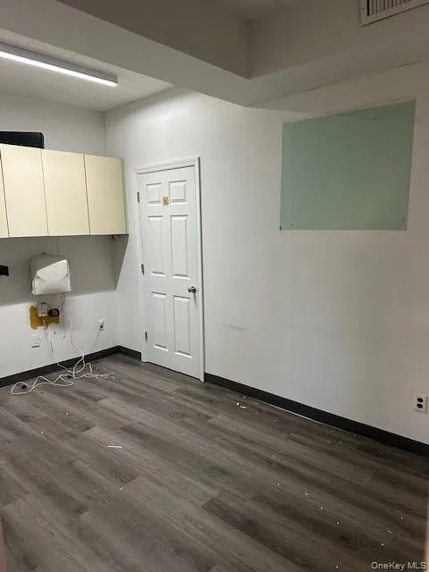 Laundry area with baseboards and dark wood-type flooring Laundry area with baseboards and dark wood-type flooring
