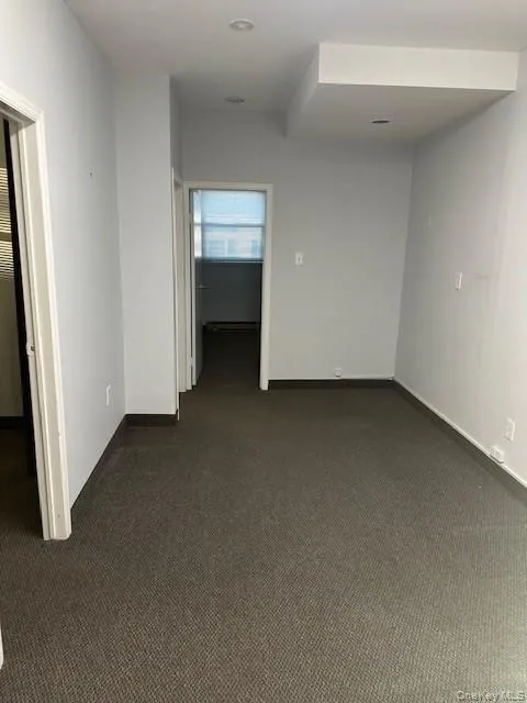 Spare room featuring dark colored carpet Spare room featuring dark colored carpet