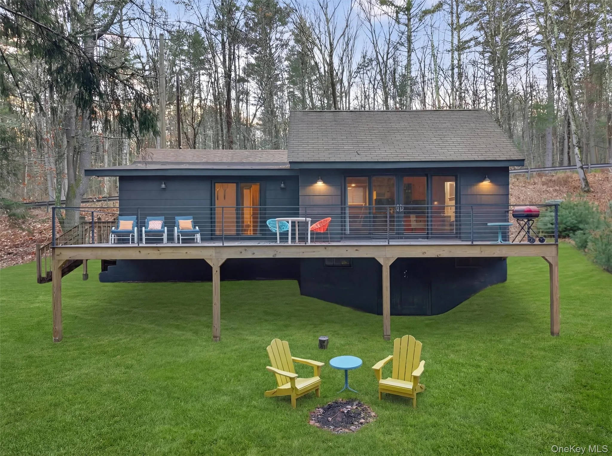 Rear view of property with a lawn, a deck, and roof with shingles Rear view of property with a lawn, a deck, and roof with shingles