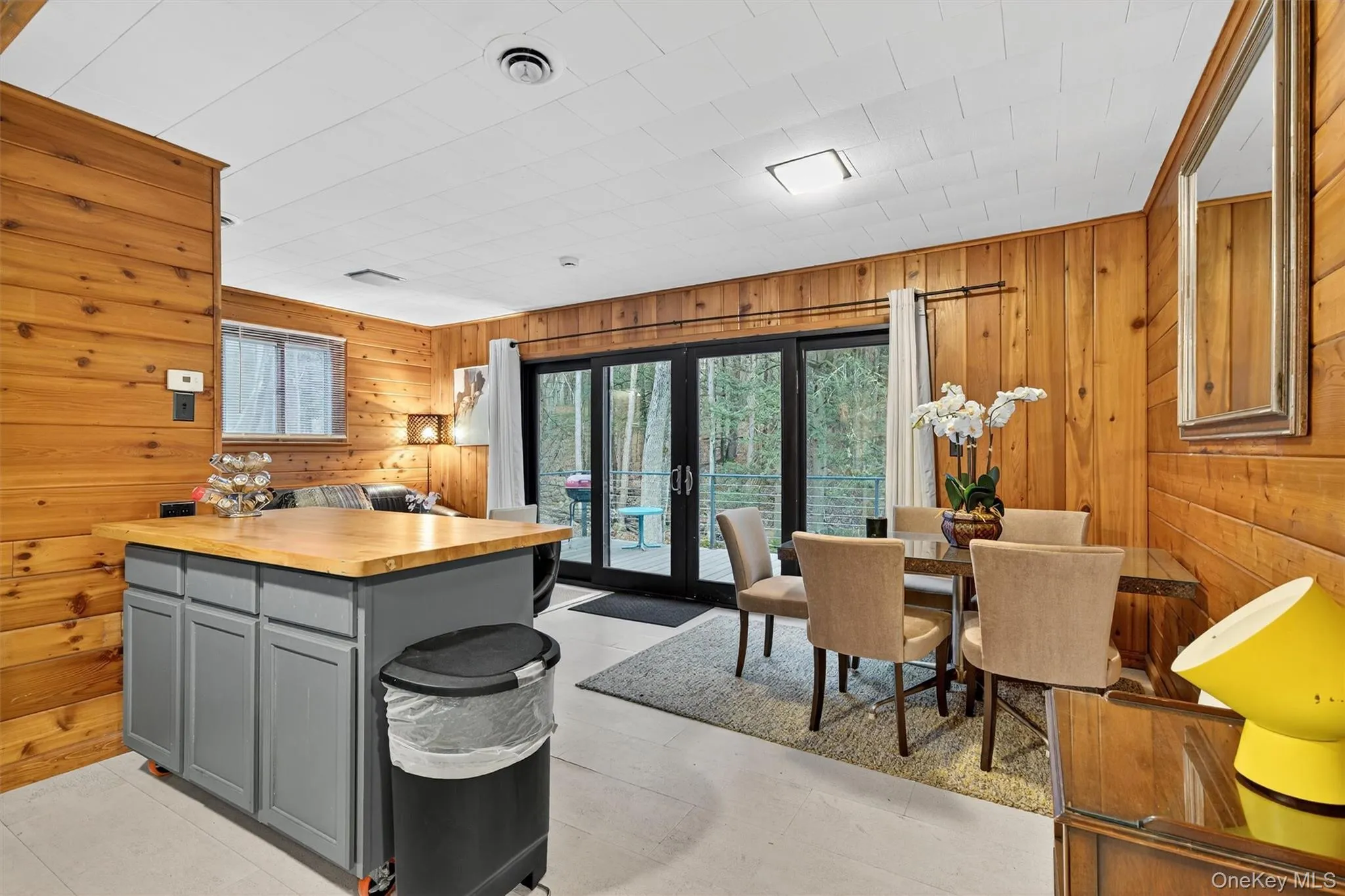 Kitchen featuring butcher block counters, gray cabinetry, wooden walls, french doors, and a center island Kitchen featuring butcher block counters, gray cabinetry, wooden walls, french doors, and a center island
