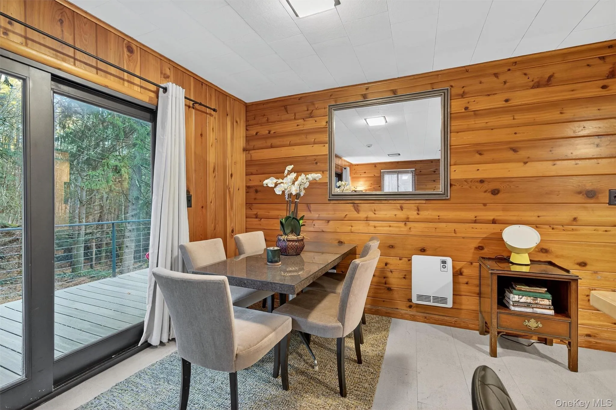 Dining space featuring wood walls and heating unit Dining space featuring wood walls and heating unit