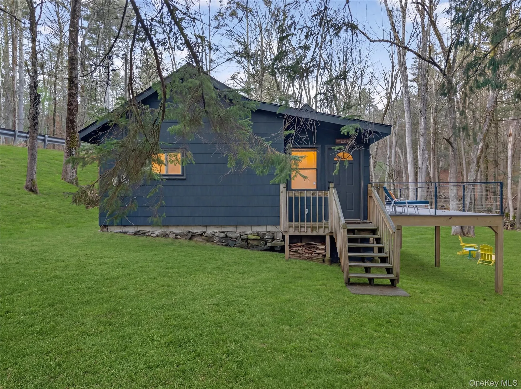 View of front of property with a front yard and a deck View of front of property with a front yard and a deck
