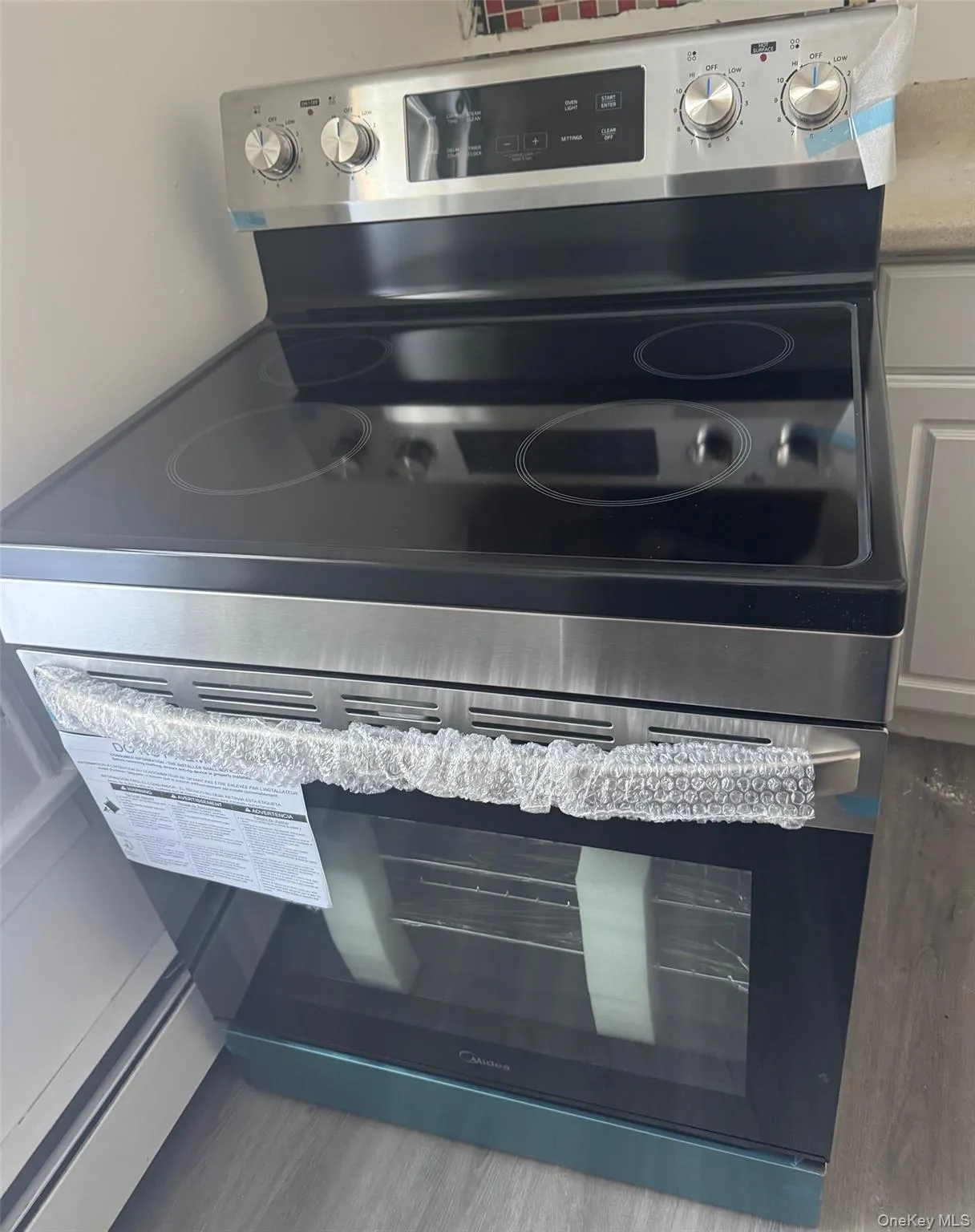 Kitchen view of stainless steel range with electric cooktop and light stone countertops Kitchen view of stainless steel range with electric cooktop and light stone countertops