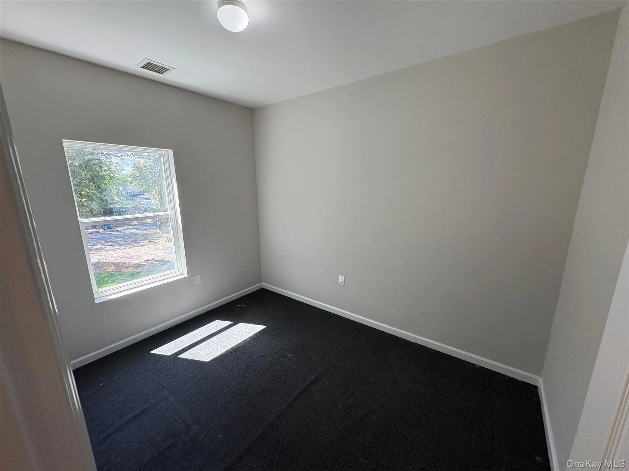 Spare room with carpet flooring and baseboards Spare room with carpet flooring and baseboards