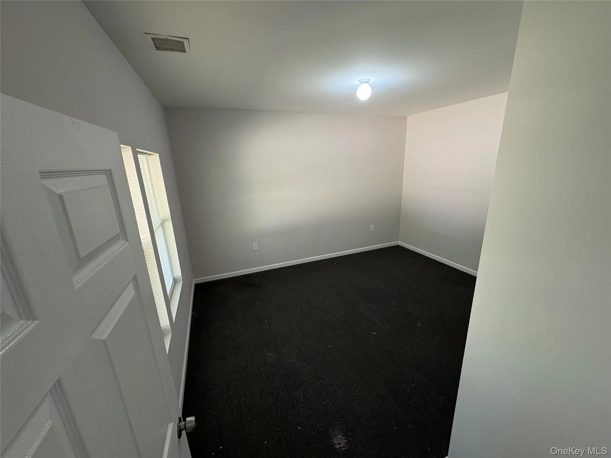 Unfurnished room with carpet and baseboards Unfurnished room with carpet and baseboards