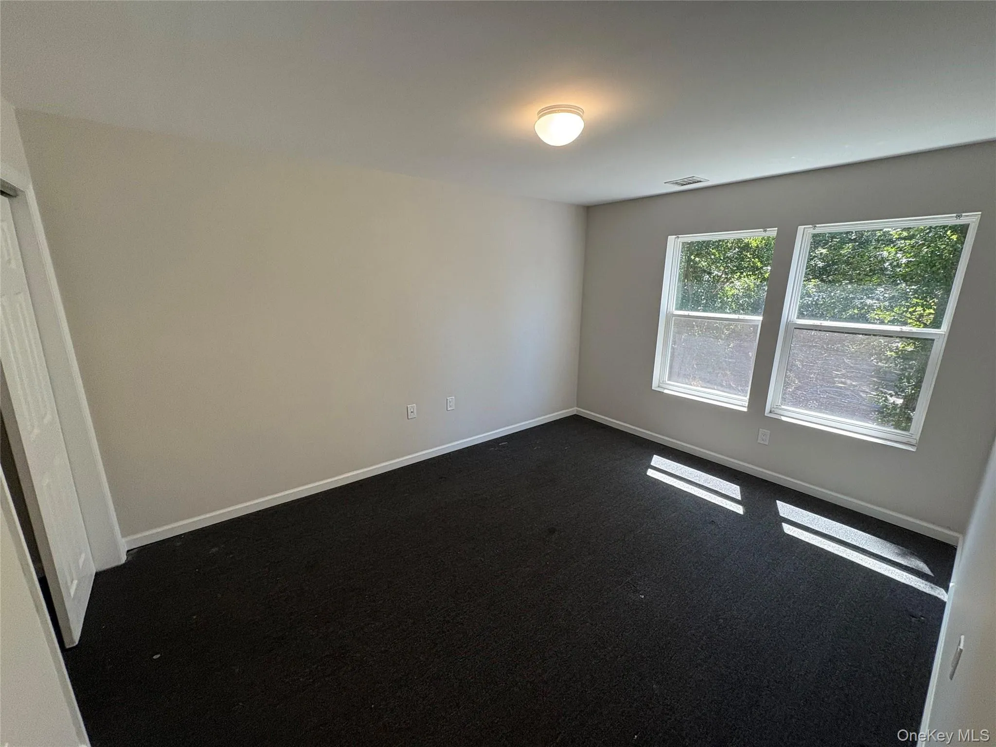 Carpeted empty room featuring baseboards Carpeted empty room featuring baseboards
