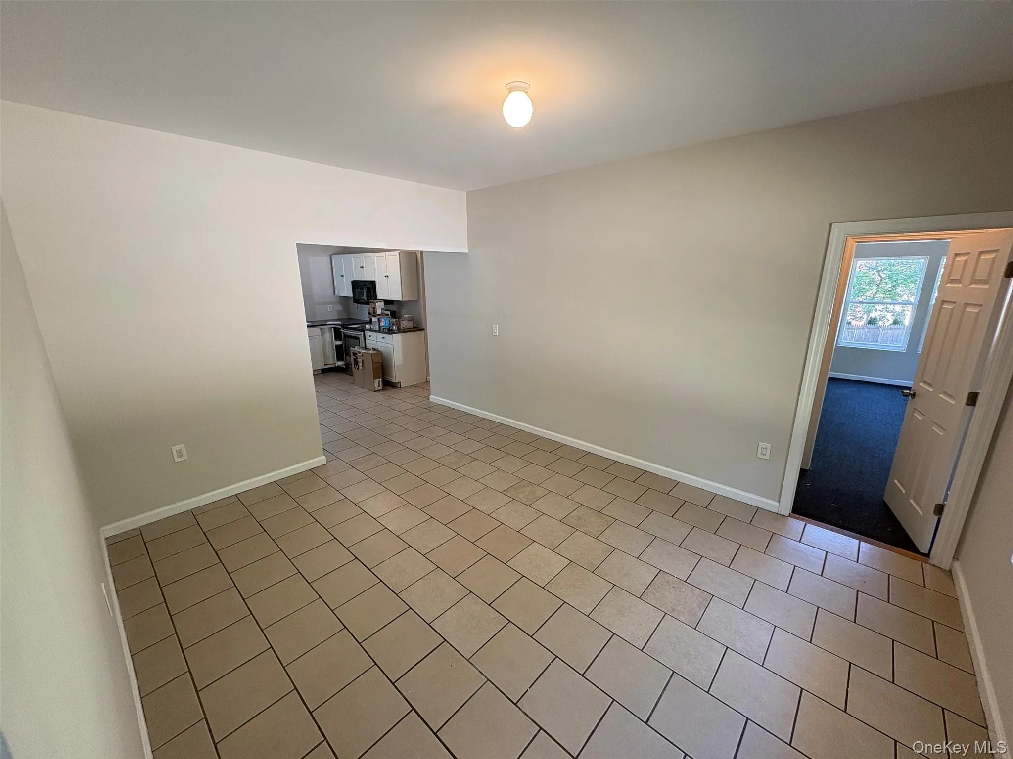 Empty room featuring baseboards and light tile patterned floors Empty room featuring baseboards and light tile patterned floors