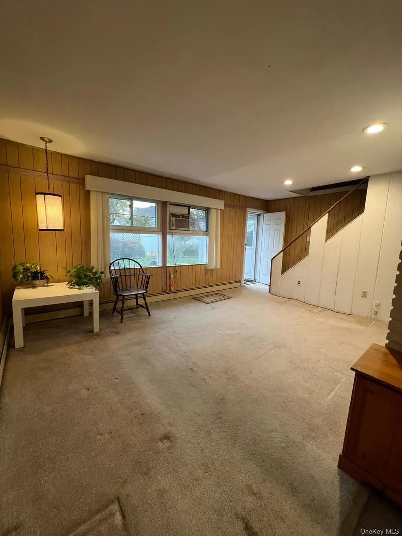 Unfurnished room featuring recessed lighting, carpet floors, and wood walls Unfurnished room featuring recessed lighting, carpet floors, and wood walls