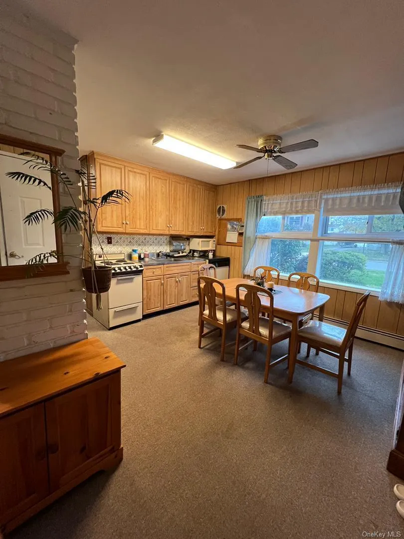Dining area with light colored carpet, ceiling fan, and baseboard heating Dining area with light colored carpet, ceiling fan, and baseboard heating