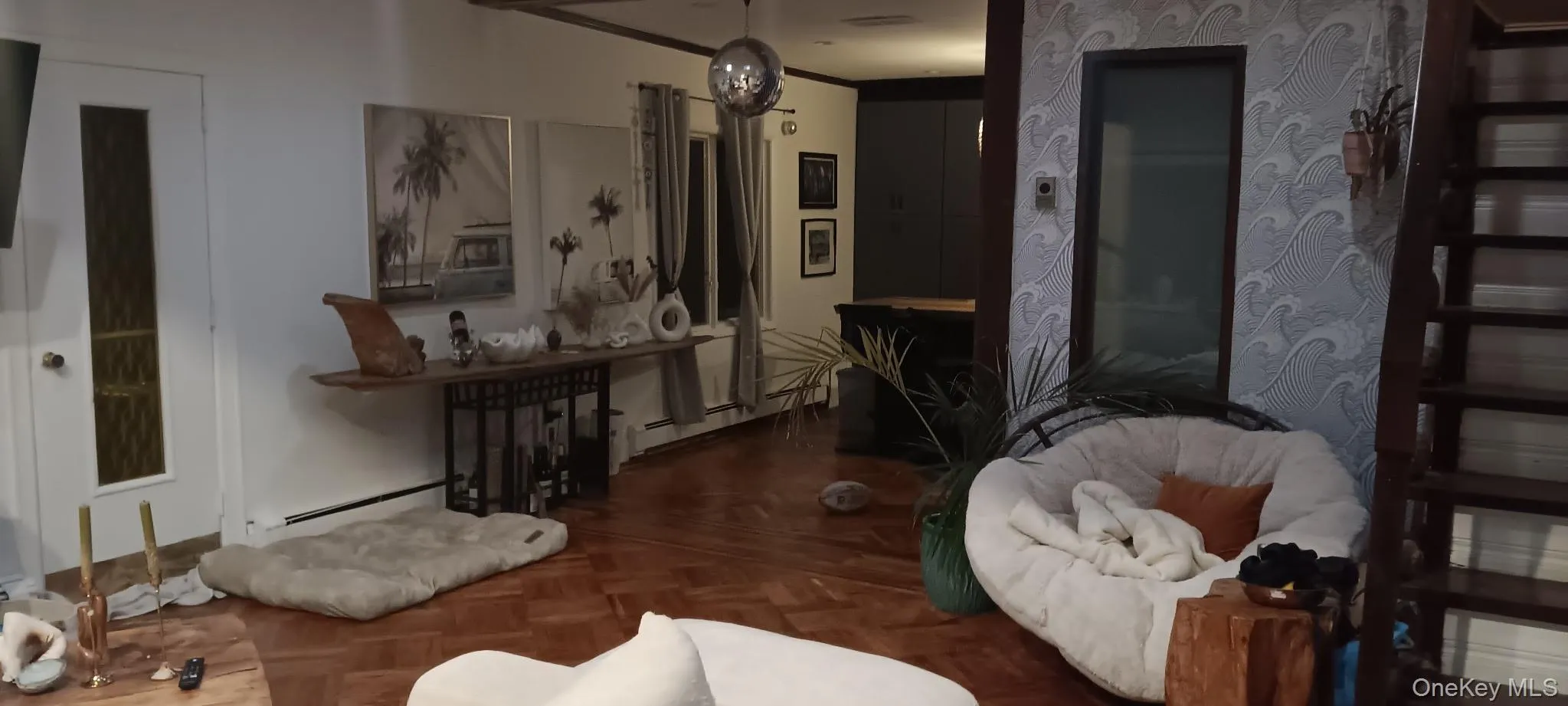 Living room featuring a baseboard radiator, crown molding, and a chandelier Living room featuring a baseboard radiator, crown molding, and a chandelier