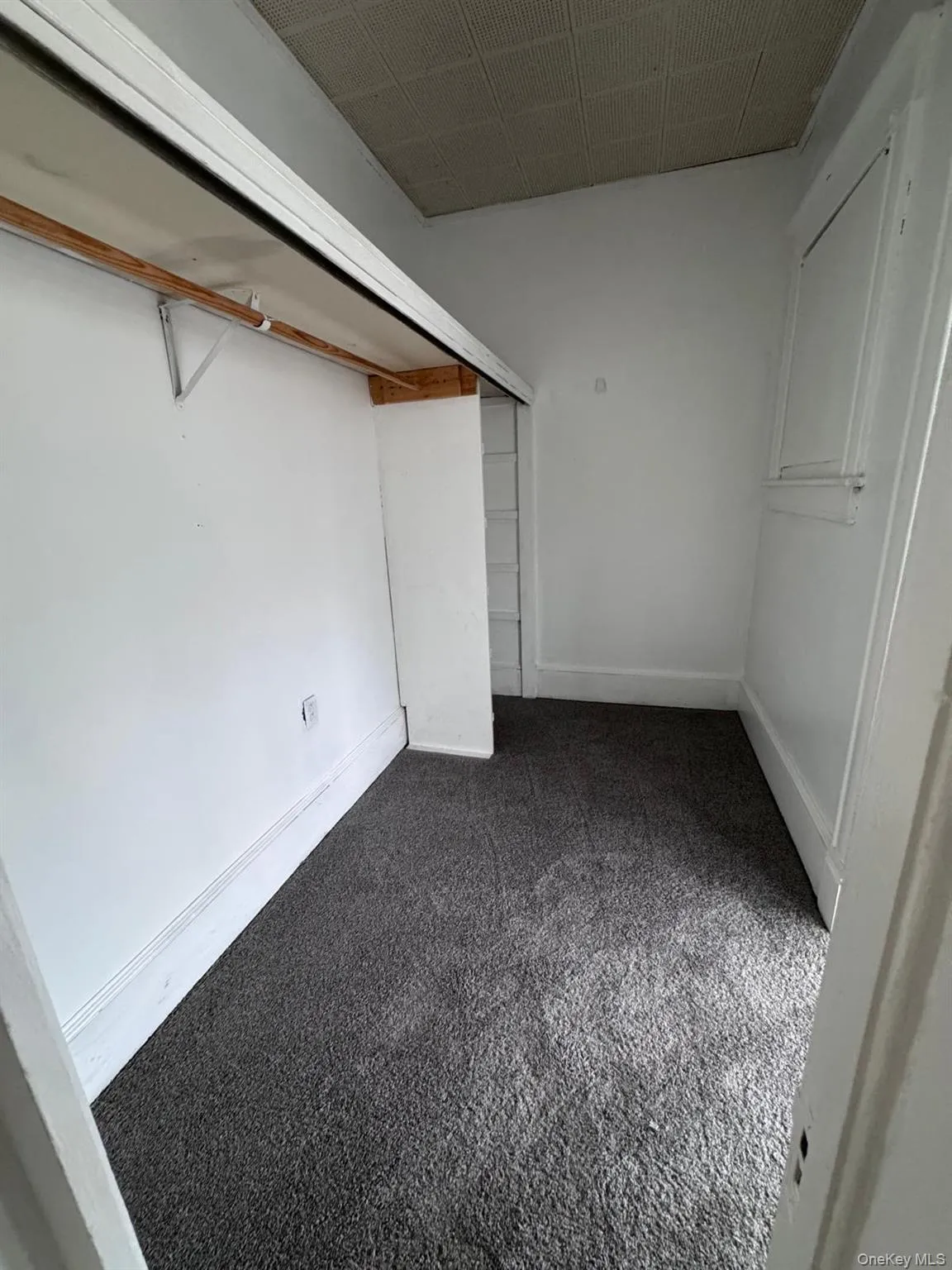 Below grade area with baseboards and dark carpet Below grade area with baseboards and dark carpet