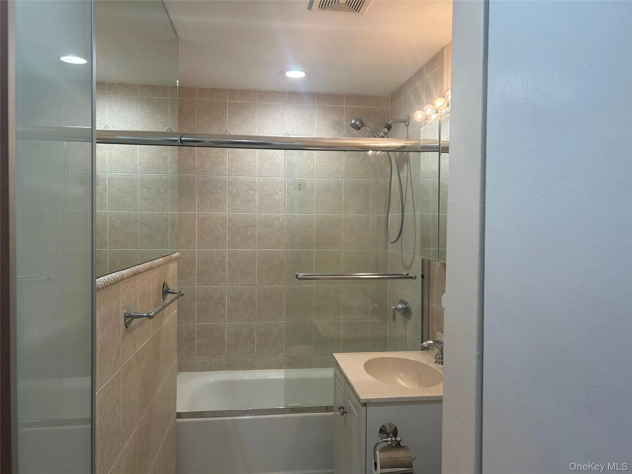 Full bath with vanity and combined bath / shower with glass door Full bath with vanity and combined bath / shower with glass door