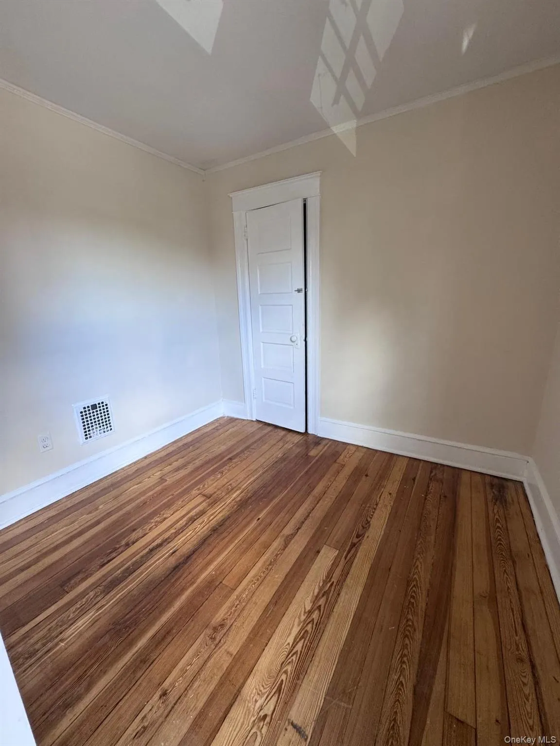 Unfurnished room with hardwood / wood-style floors, crown molding, and a skylight Unfurnished room with hardwood / wood-style floors, crown molding, and a skylight