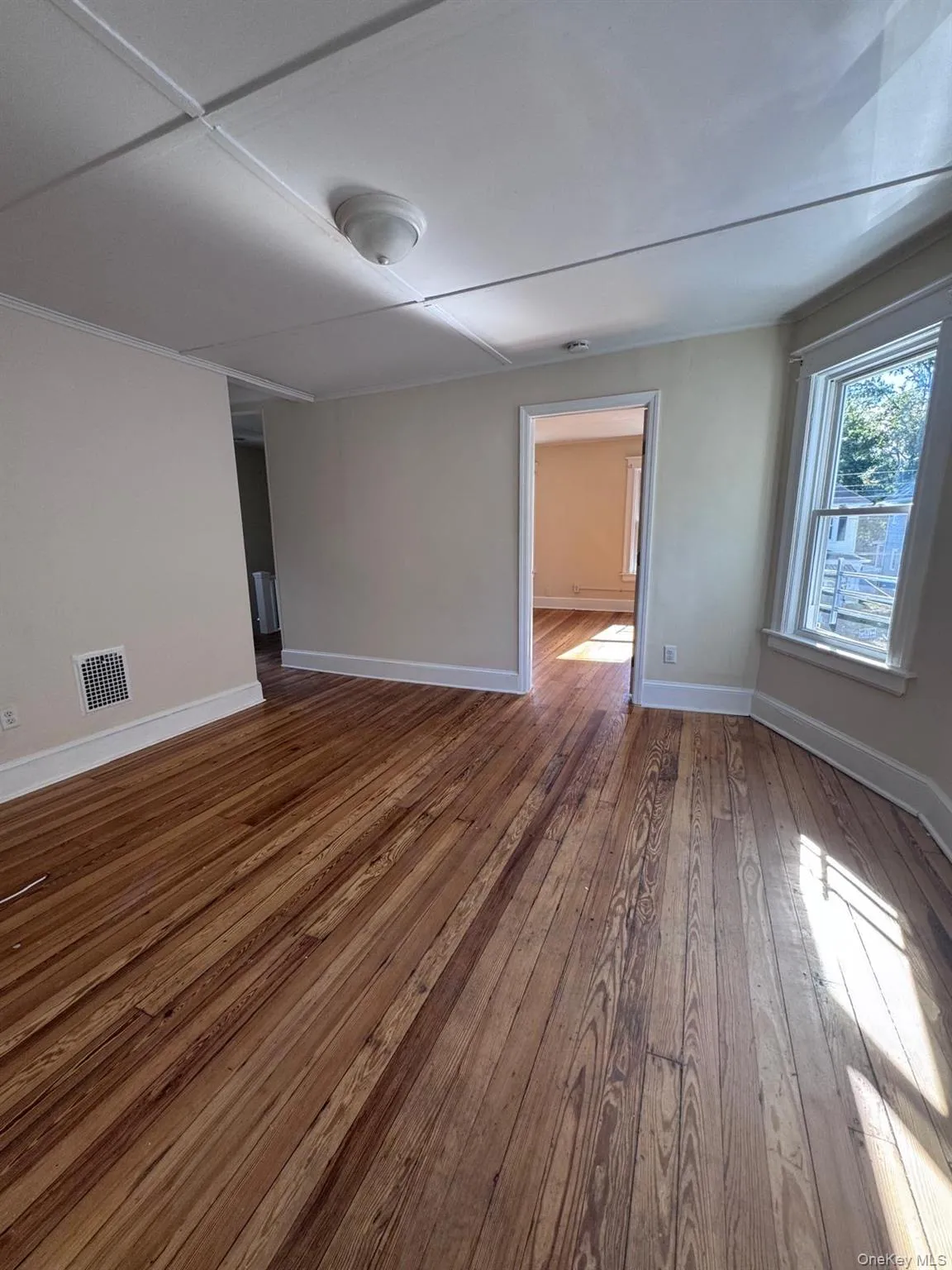 Spare room with baseboards and dark wood finished floors Spare room with baseboards and dark wood finished floors