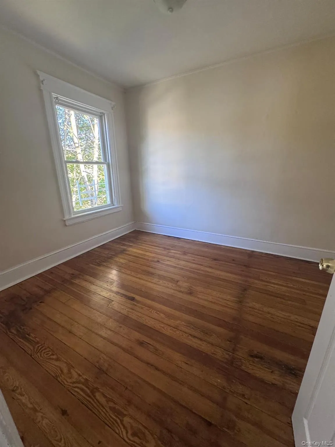 Empty room featuring baseboards and dark wood-type flooring Empty room featuring baseboards and dark wood-type flooring