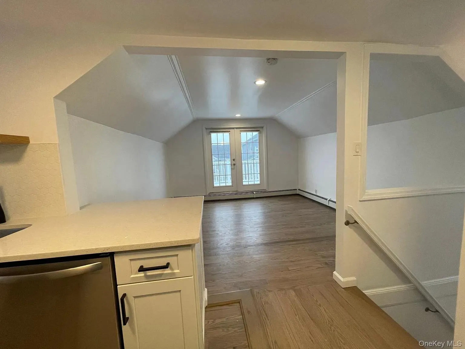 Bonus room featuring light wood-type flooring, lofted ceiling, and french doors Bonus room featuring light wood-type flooring, lofted ceiling, and french doors