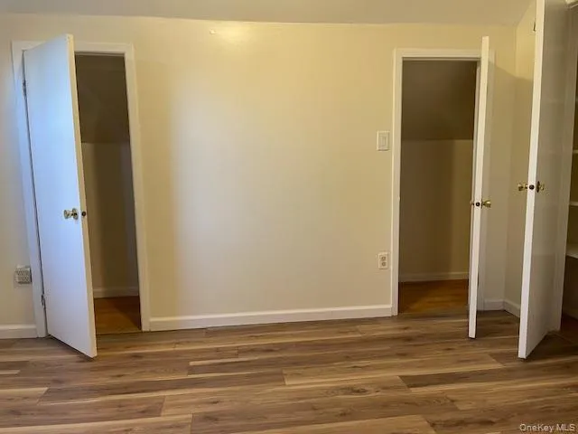 Unfurnished bedroom with dark wood-style floors Unfurnished bedroom with dark wood-style floors