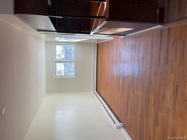 Empty room featuring a baseboard heating unit and wood finished floors Empty room featuring a baseboard heating unit and wood finished floors