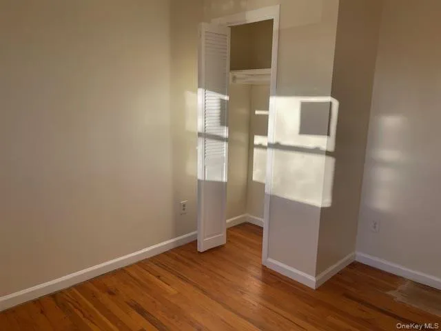 Empty room with baseboards and light wood-type flooring Empty room with baseboards and light wood-type flooring
