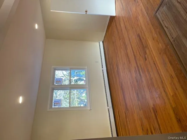 Empty room featuring a baseboard radiator, light wood-style floors, and recessed lighting Empty room featuring a baseboard radiator, light wood-style floors, and recessed lighting