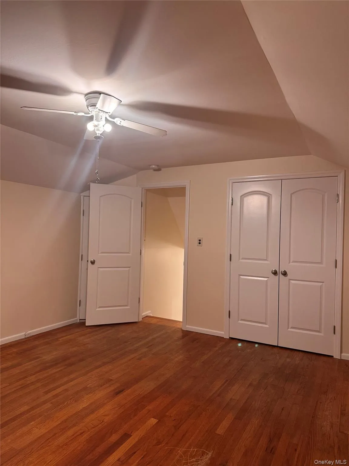 Additional living space featuring lofted ceiling, dark wood-style flooring, and ceiling fan Additional living space featuring lofted ceiling, dark wood-style flooring, and ceiling fan
