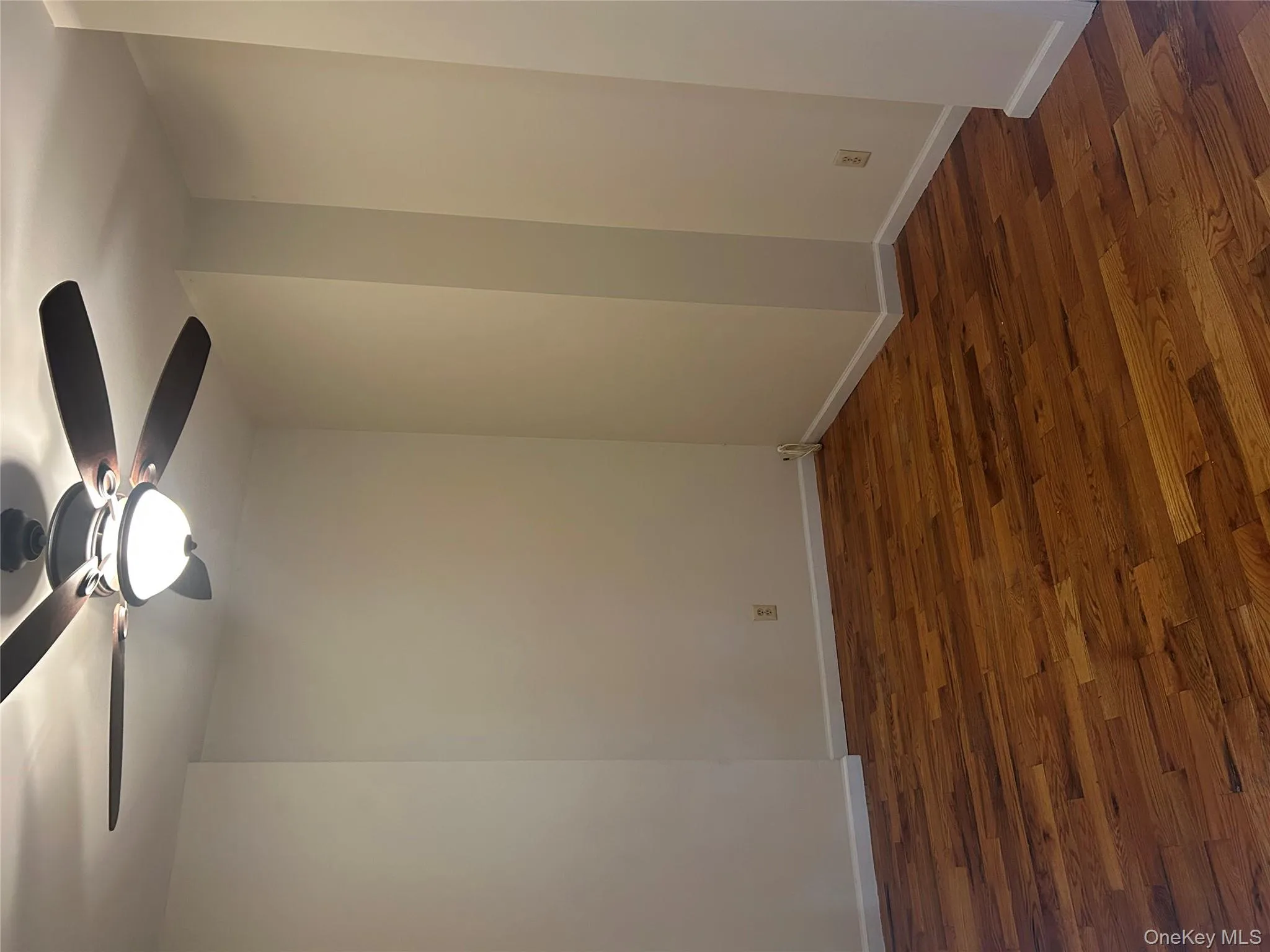 Empty room featuring dark wood-style flooring and ceiling fan Empty room featuring dark wood-style flooring and ceiling fan