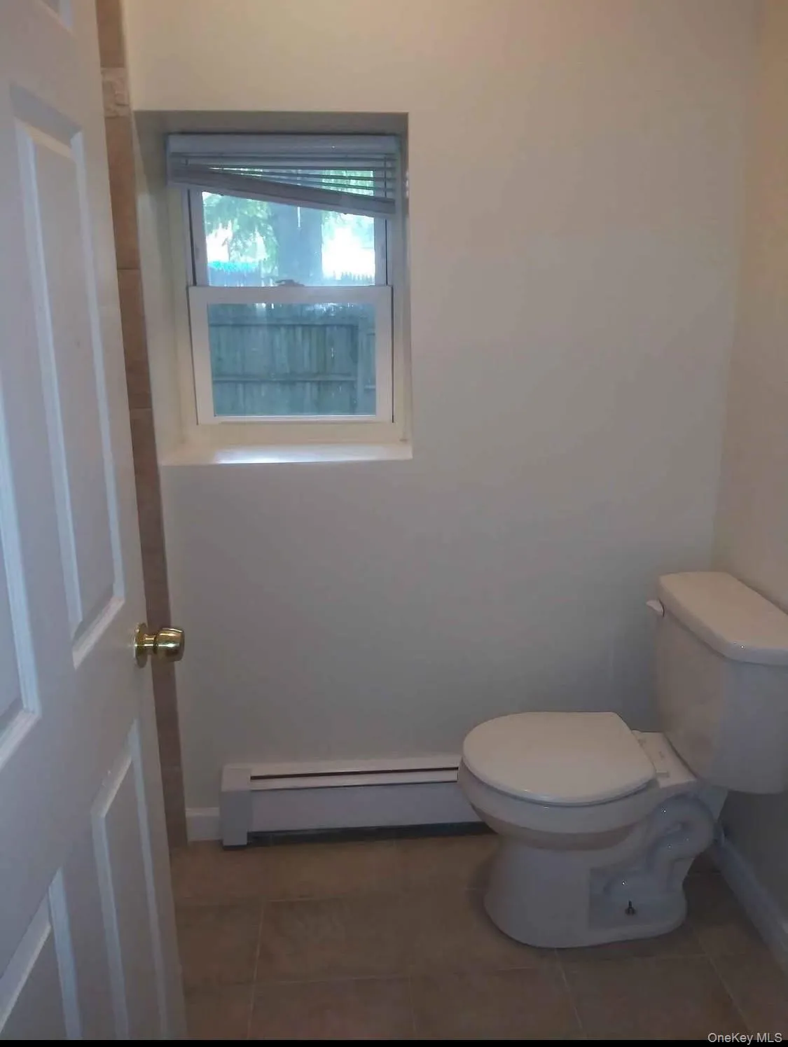 Bathroom featuring a baseboard heating unit and tile patterned floors Bathroom featuring a baseboard heating unit and tile patterned floors