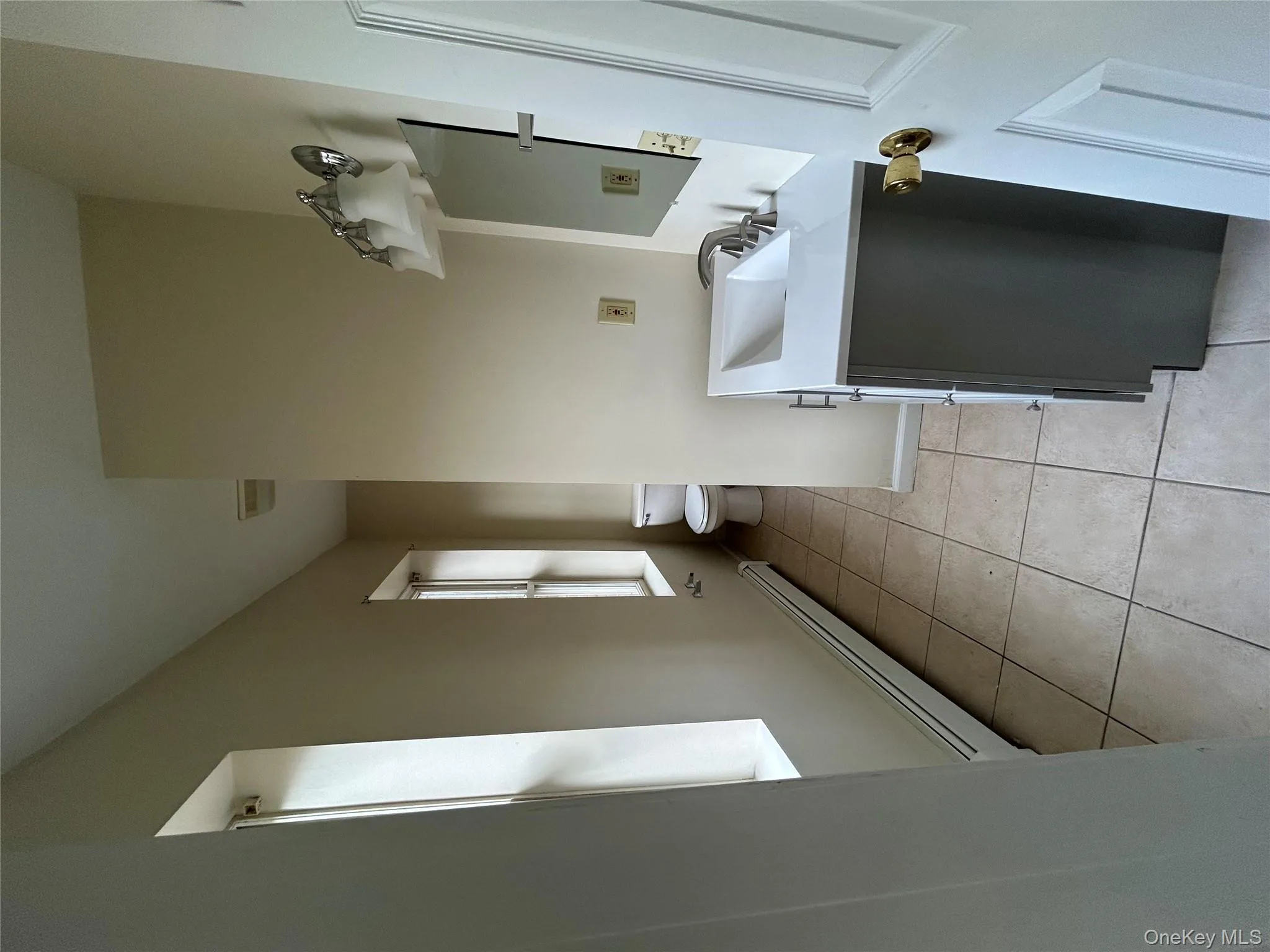 Half bath with a baseboard radiator, light tile patterned floors, and vanity Half bath with a baseboard radiator, light tile patterned floors, and vanity