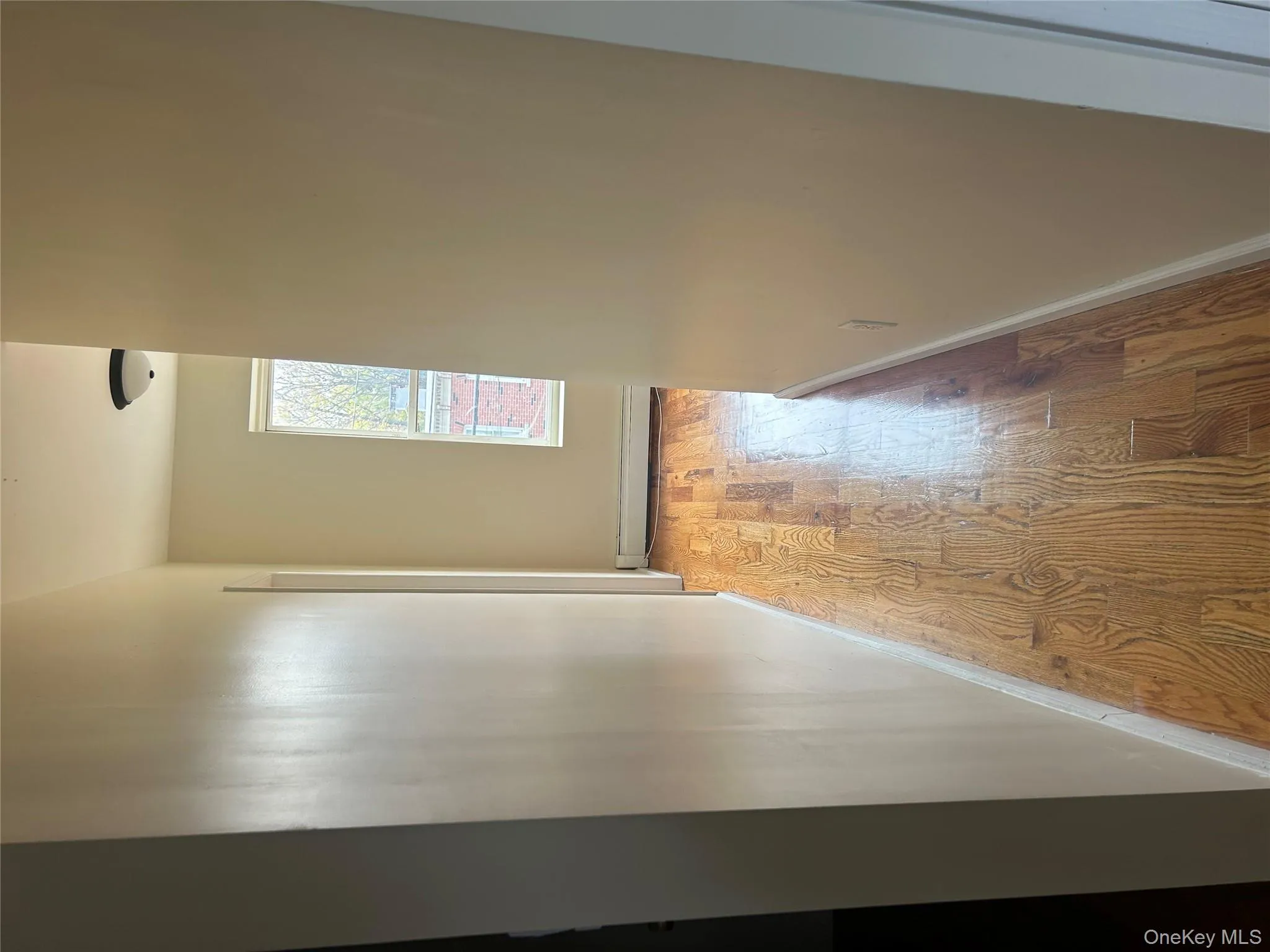 Hallway with wood finished floors and a baseboard heating unit Hallway with wood finished floors and a baseboard heating unit