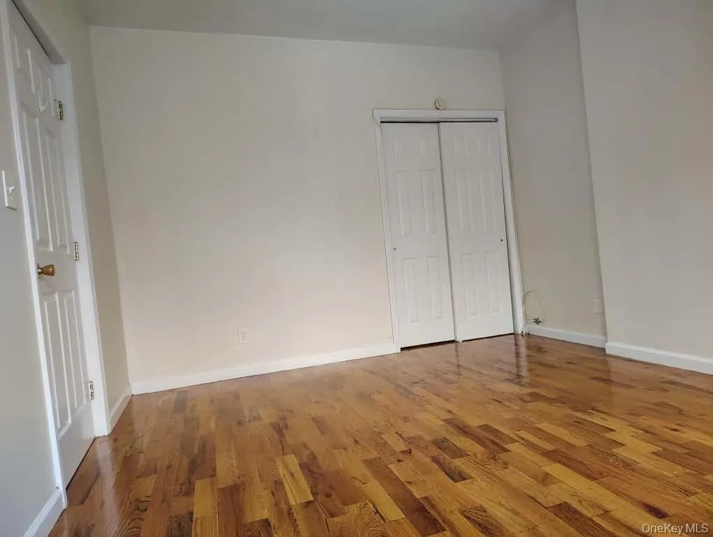 Unfurnished bedroom with wood finished floors and a closet Unfurnished bedroom with wood finished floors and a closet
