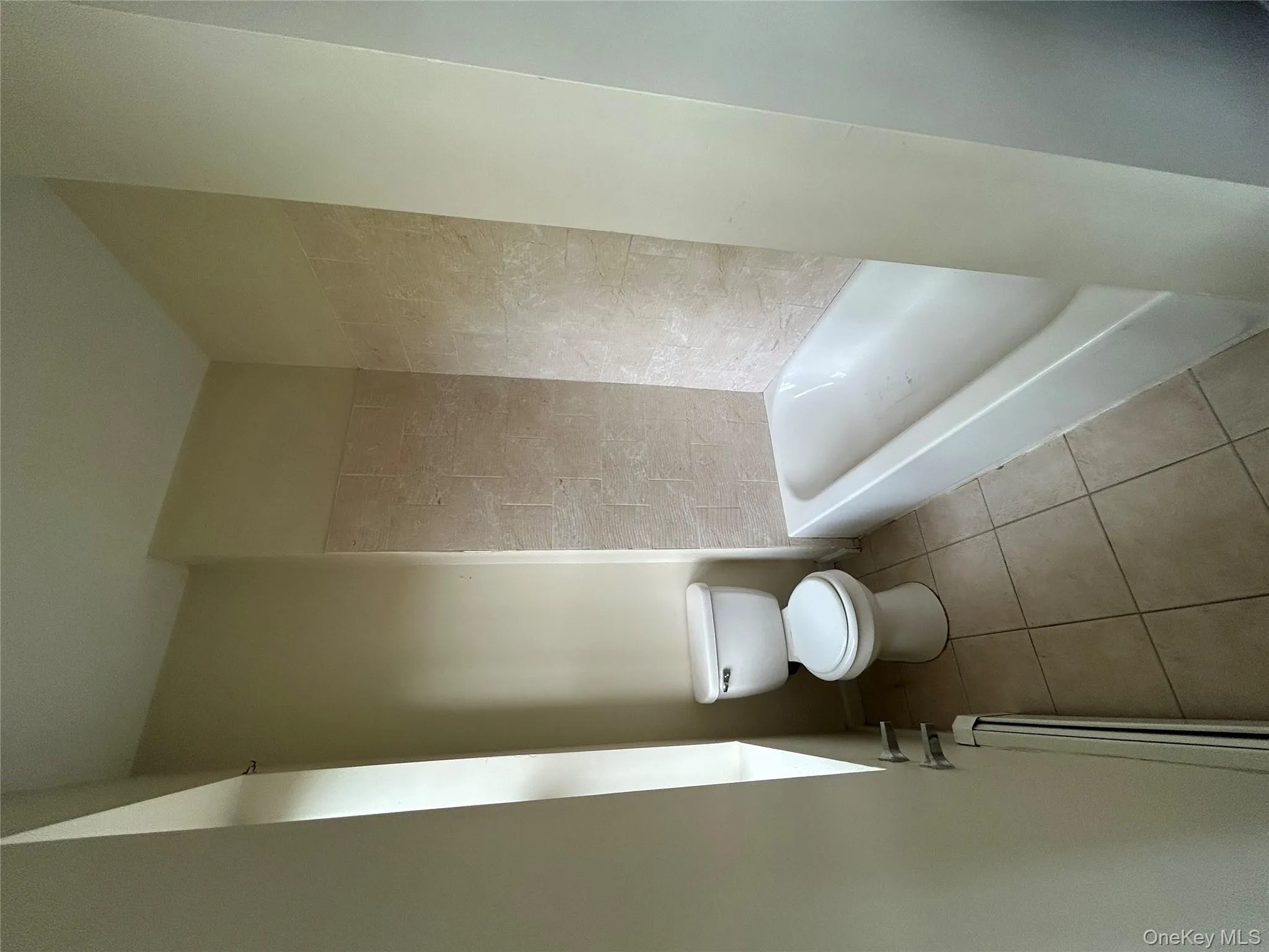 Full bathroom with tile patterned flooring and baseboard heating Full bathroom with tile patterned flooring and baseboard heating