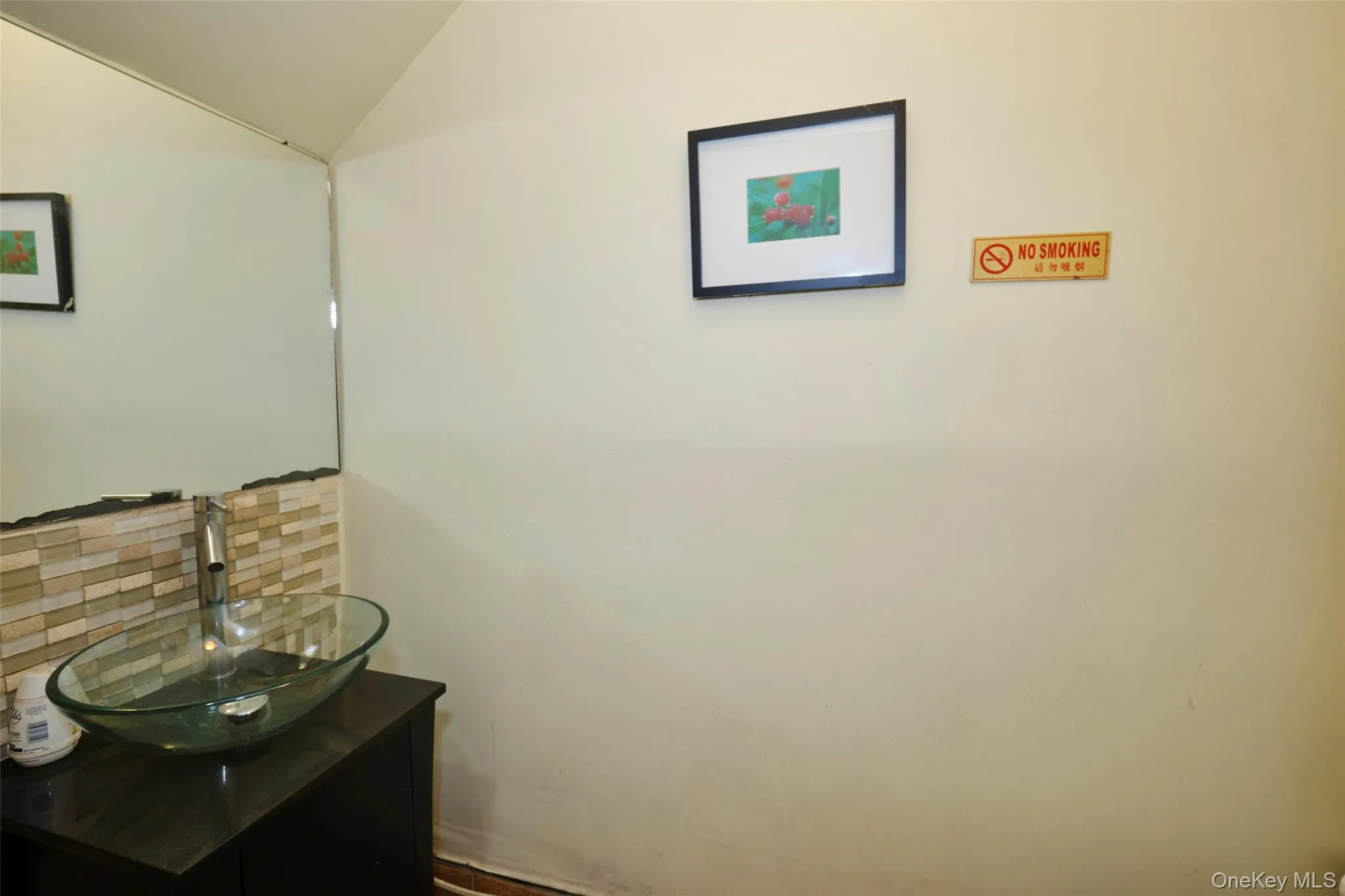 Bathroom featuring tasteful backsplash, vanity, and lofted ceiling Bathroom featuring tasteful backsplash, vanity, and lofted ceiling