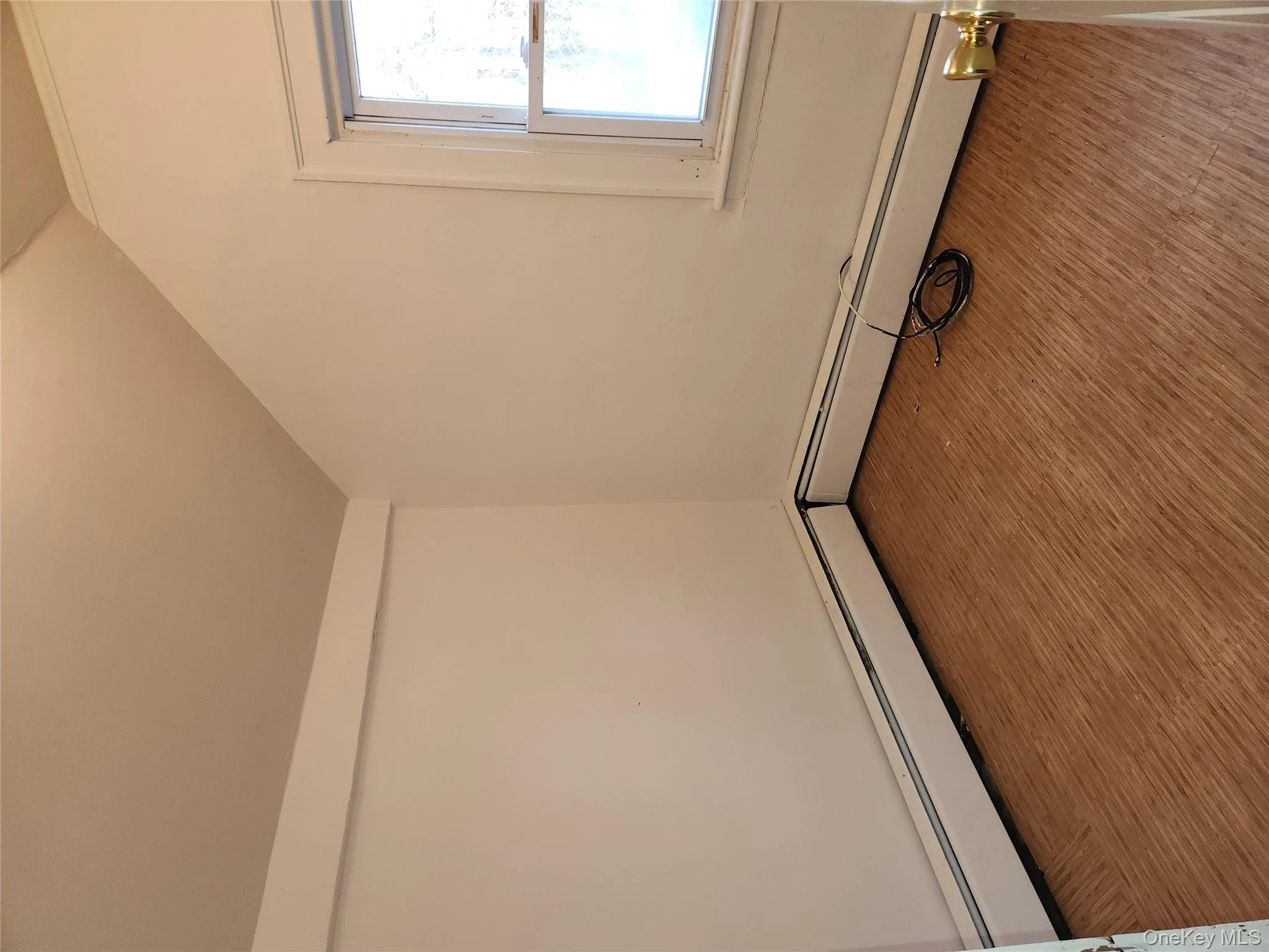 Empty room with a baseboard radiator, lofted ceiling, and wood finished floors Empty room with a baseboard radiator, lofted ceiling, and wood finished floors
