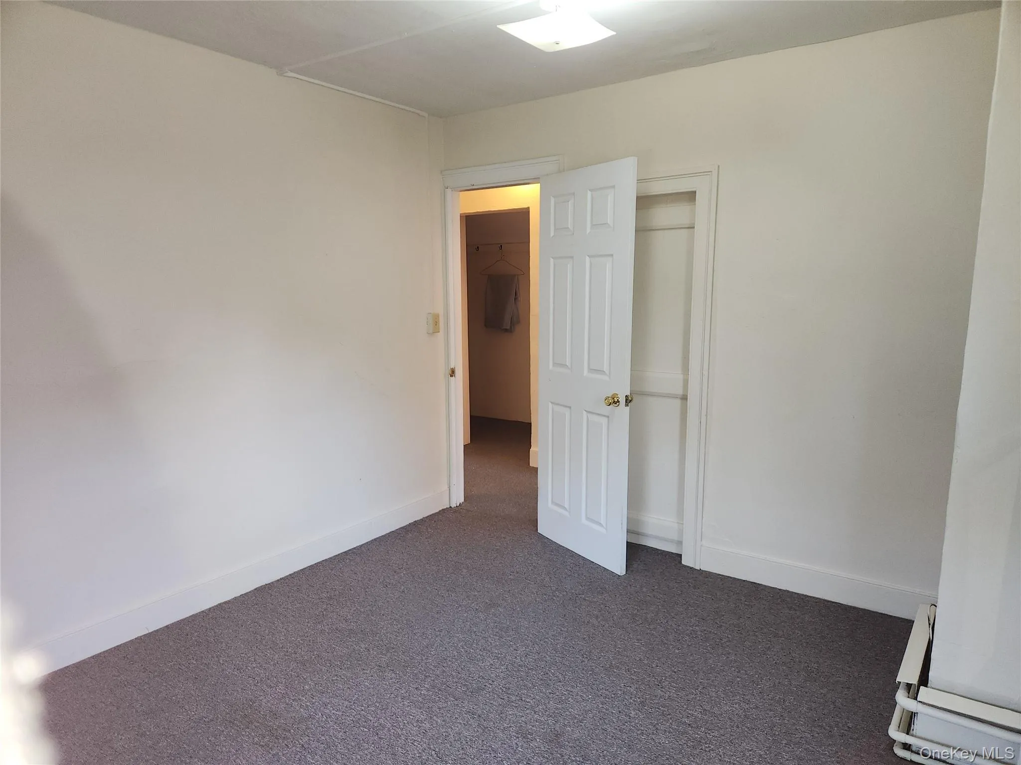 Unfurnished room featuring dark colored carpet and baseboards Unfurnished room featuring dark colored carpet and baseboards