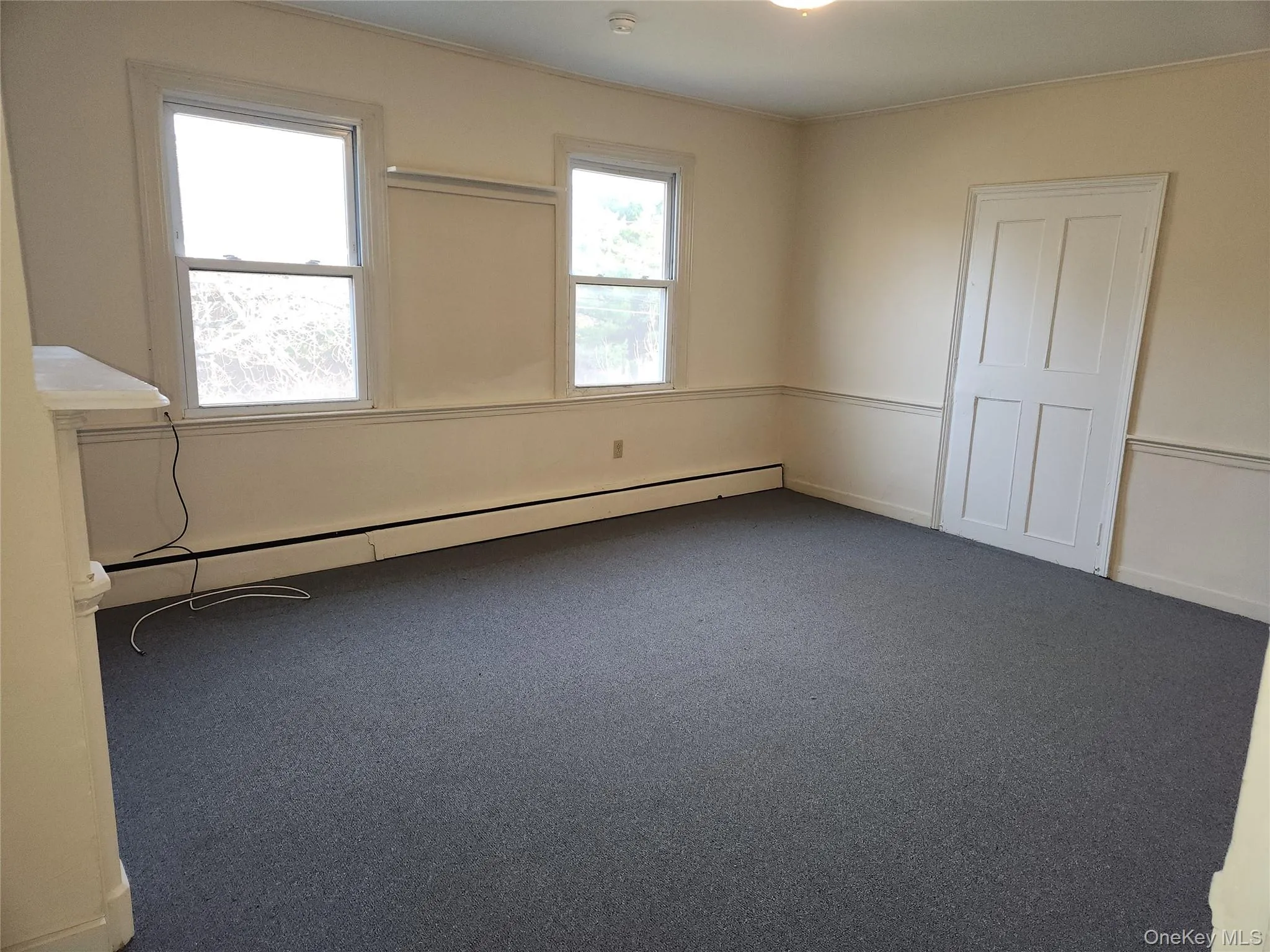 Carpeted empty room with baseboard heating Carpeted empty room with baseboard heating