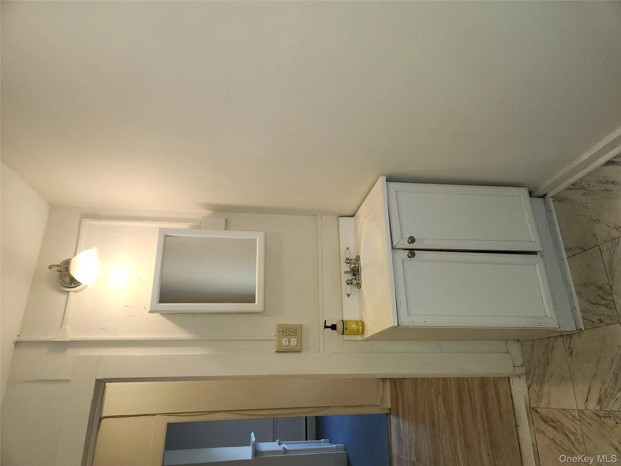 Half bath with light marble finish flooring and vanity Half bath with light marble finish flooring and vanity