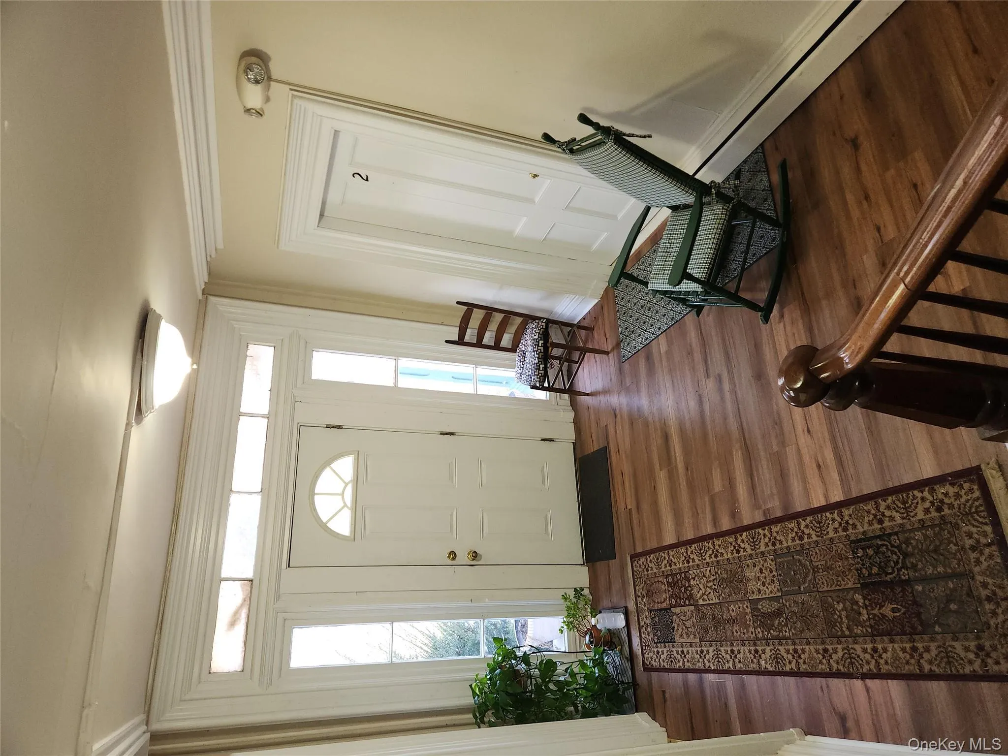 Entrance foyer with baseboard heating, dark wood finished floors, plenty of natural light, and ornamental molding Entrance foyer with baseboard heating, dark wood finished floors, plenty of natural light, and ornamental molding