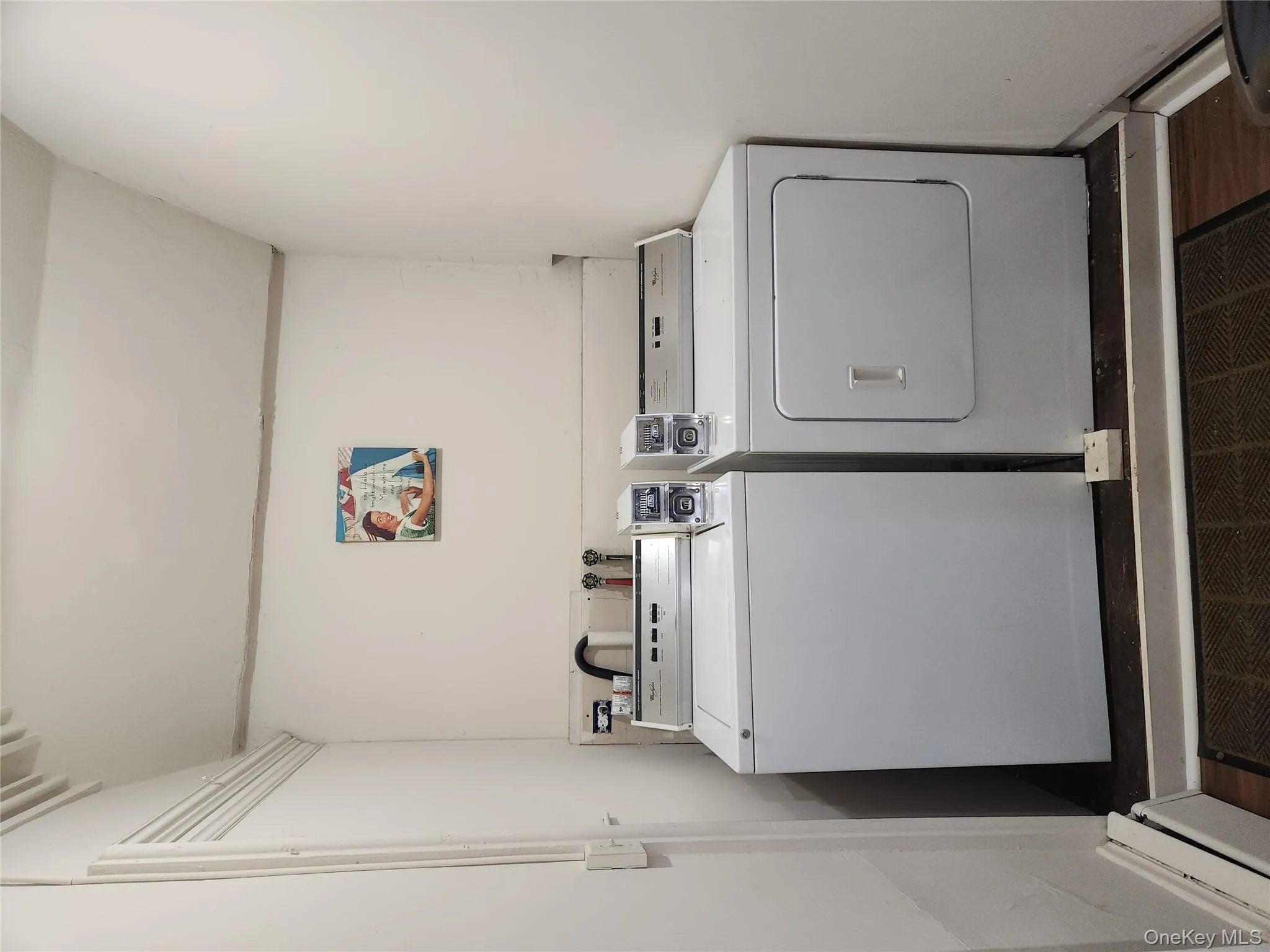 Washroom featuring washer and clothes dryer and a baseboard radiator Washroom featuring washer and clothes dryer and a baseboard radiator