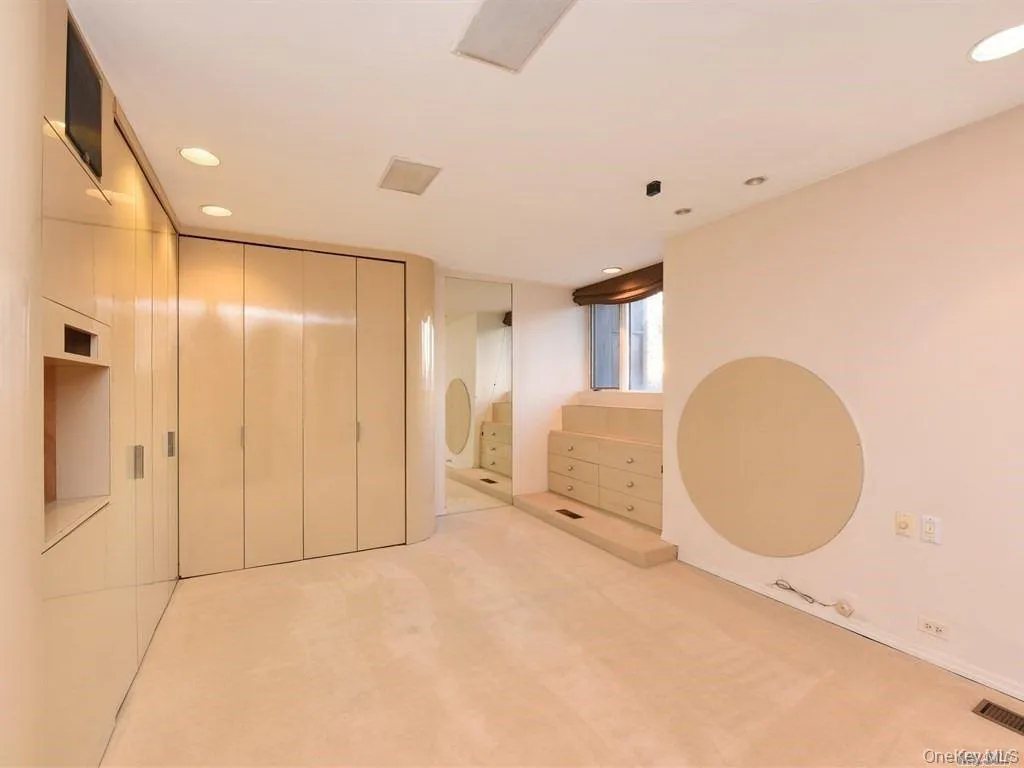 Unfurnished bedroom with light carpet, a closet, and recessed lighting Unfurnished bedroom with light carpet, a closet, and recessed lighting