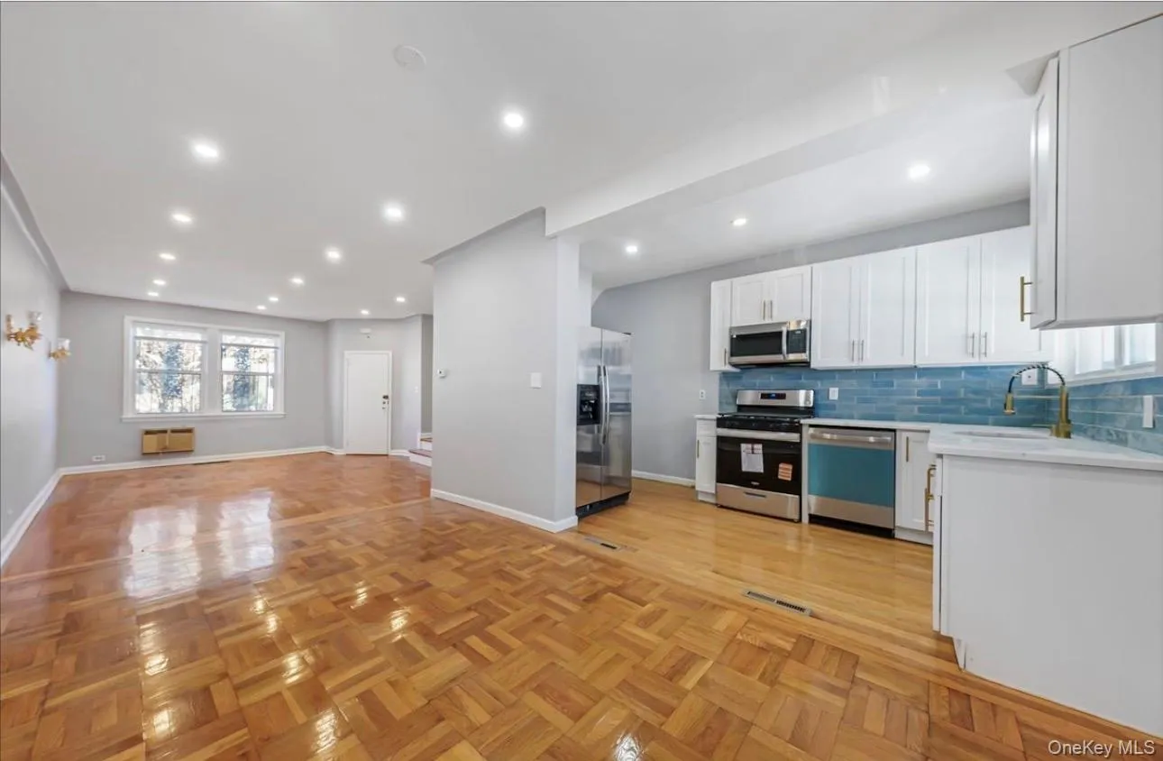 Kitchen with open floor plan, white cabinetry, stainless steel appliances, backsplash, and recessed lighting Kitchen with open floor plan, white cabinetry, stainless steel appliances, backsplash, and recessed lighting