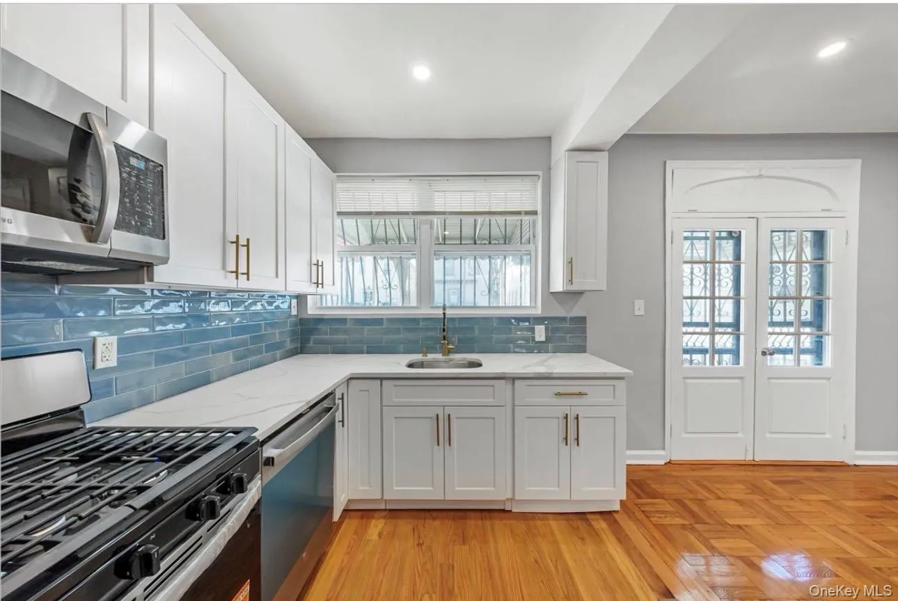Kitchen with appliances with stainless steel finishes, white cabinetry, light stone counters, tasteful backsplash, and recessed lighting Kitchen with appliances with stainless steel finishes, white cabinetry, light stone counters, tasteful backsplash, and recessed lighting