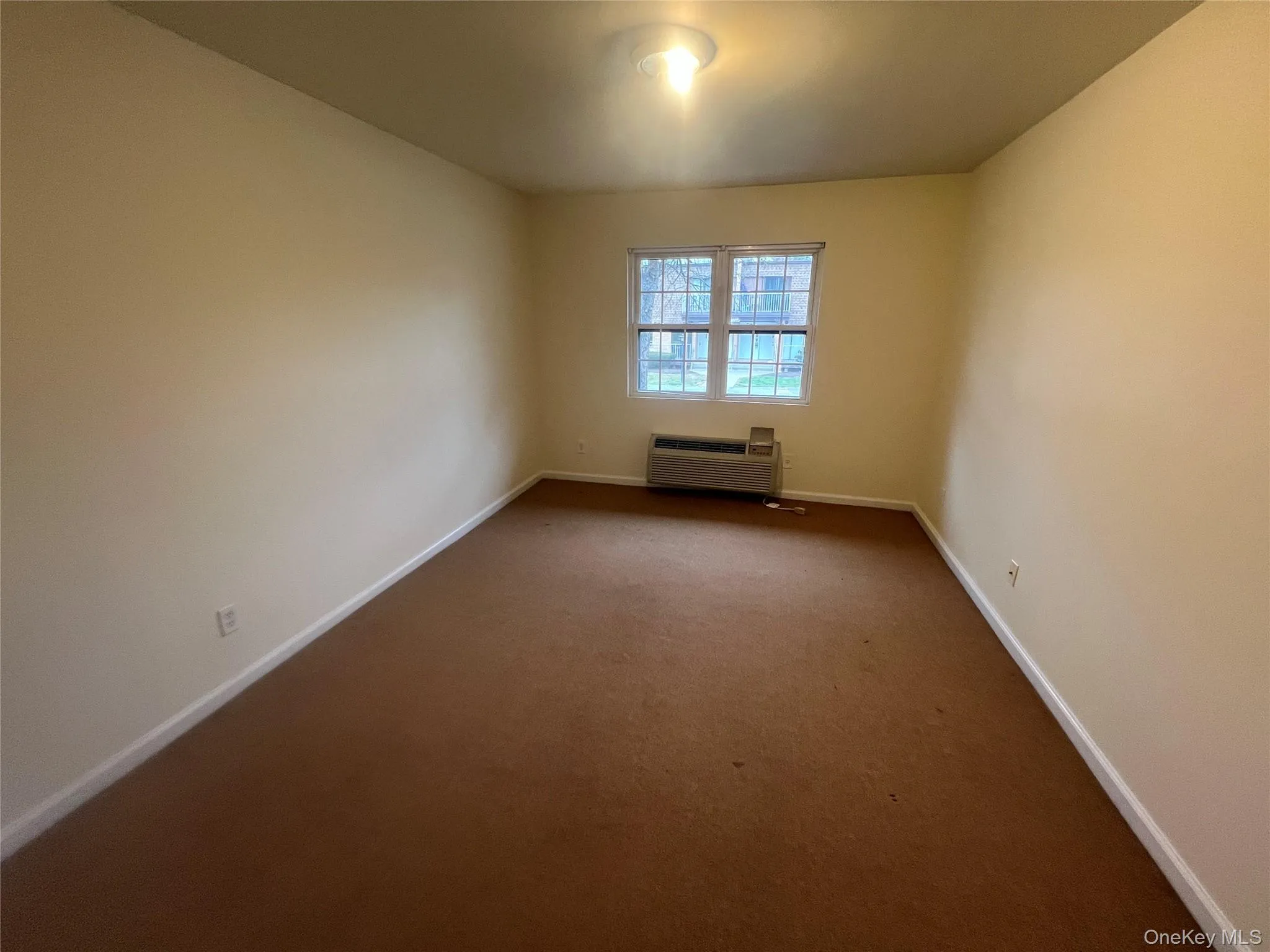 Unfurnished room with a wall unit AC and carpet flooring Unfurnished room with a wall unit AC and carpet flooring