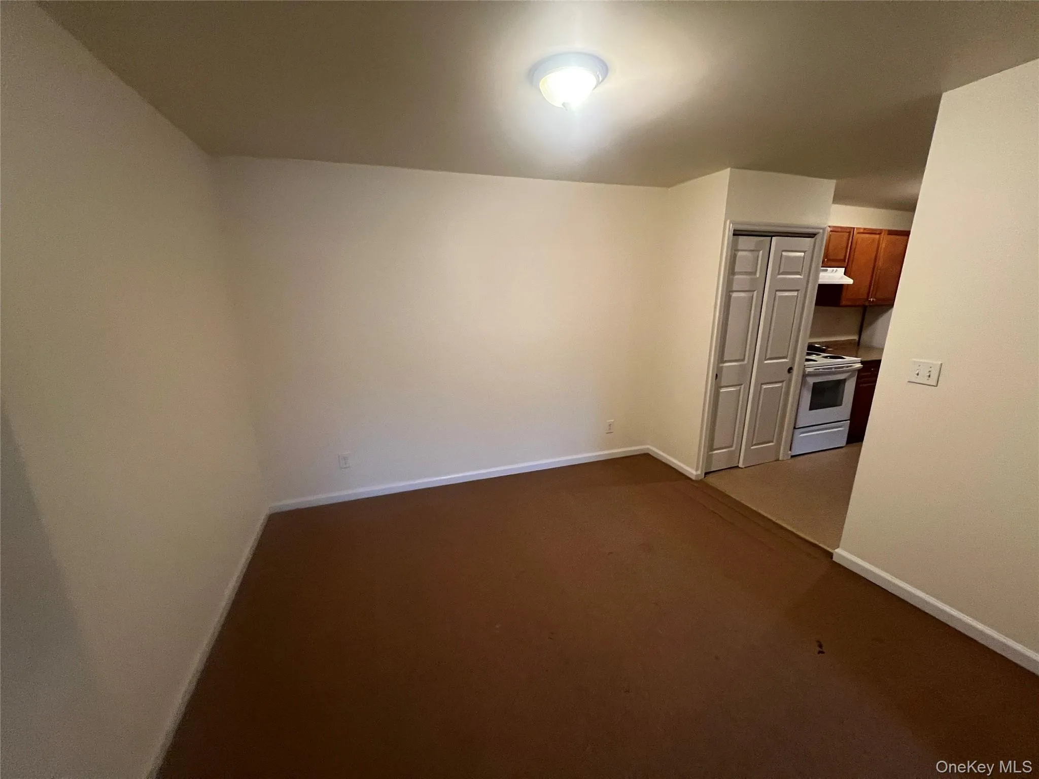 Unfurnished room featuring baseboards and dark colored carpet Unfurnished room featuring baseboards and dark colored carpet