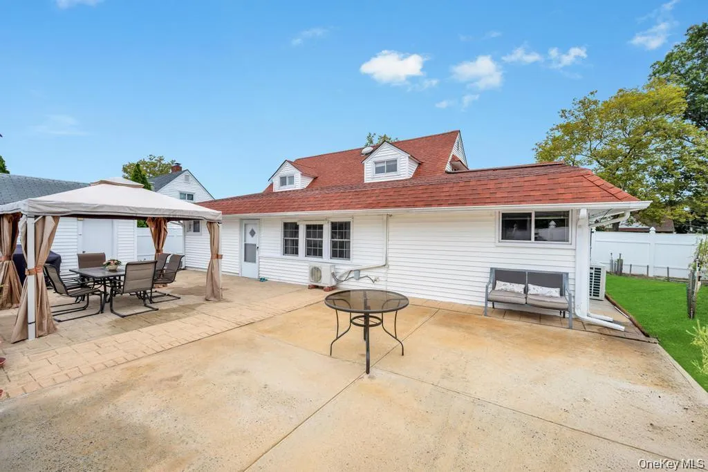 Rear view of house with a patio area, a gazebo, and outdoor dining area Rear view of house with a patio area, a gazebo, and outdoor dining area