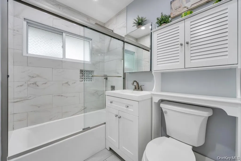 Full bath featuring vanity and enclosed tub / shower combo Full bath featuring vanity and enclosed tub / shower combo