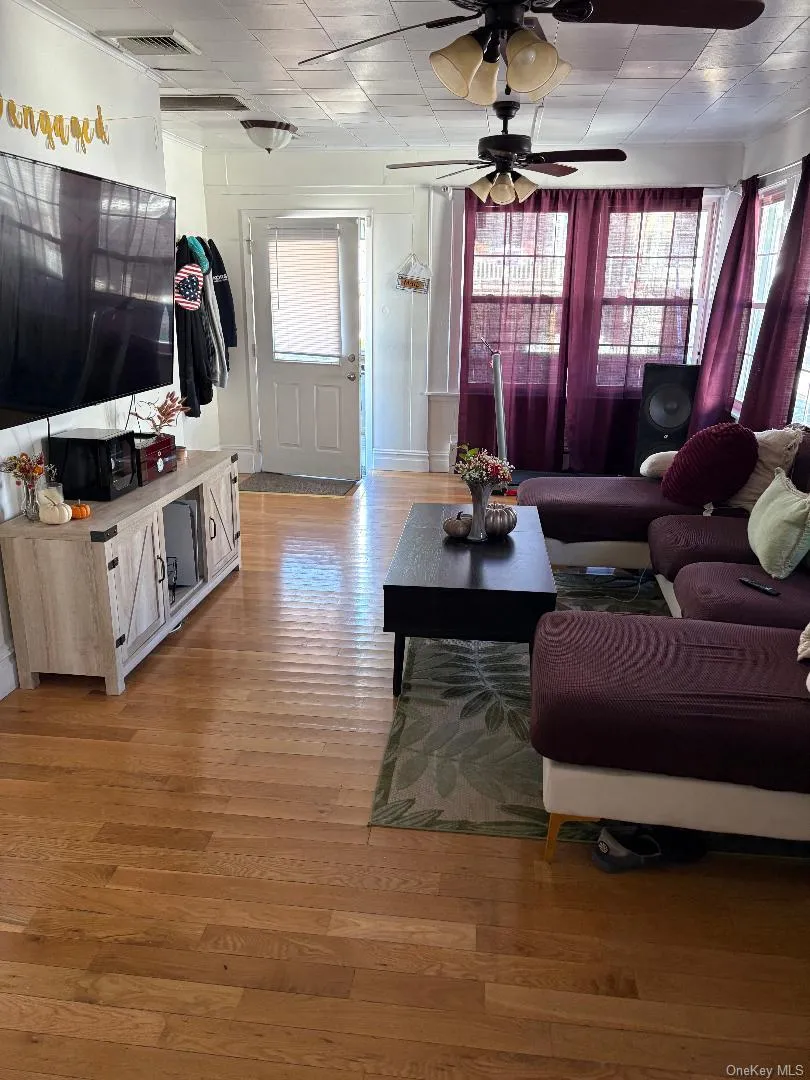 Living room featuring light wood-type flooring and ceiling fan Living room featuring light wood-type flooring and ceiling fan
