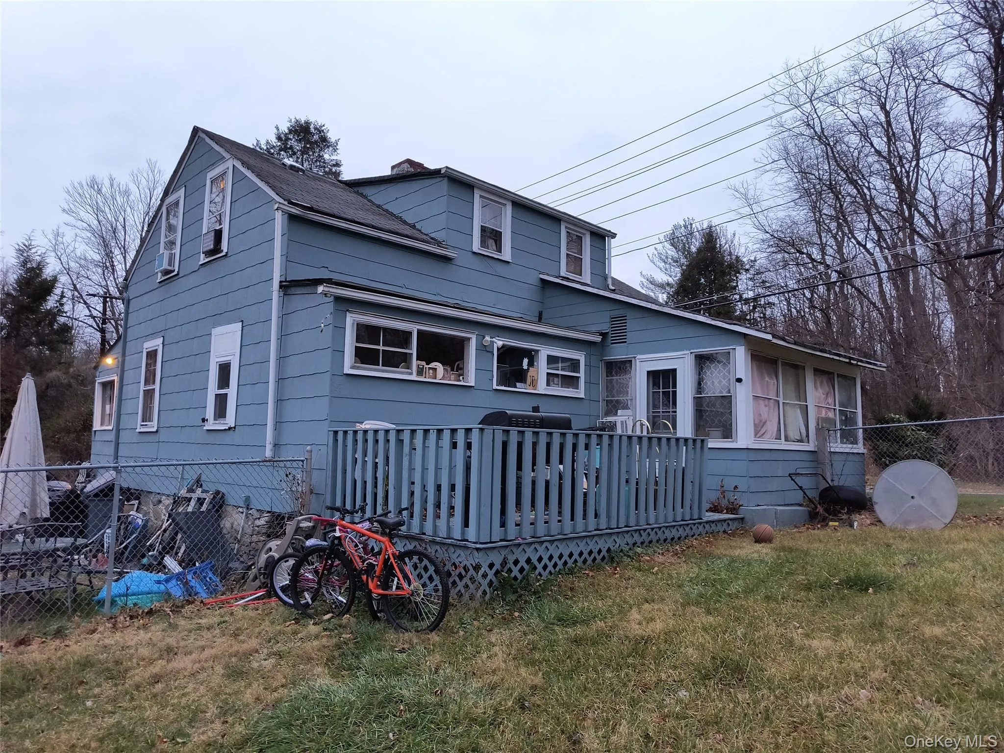 View of front of property featuring a wooden deck and a chimney View of front of property featuring a wooden deck and a chimney
